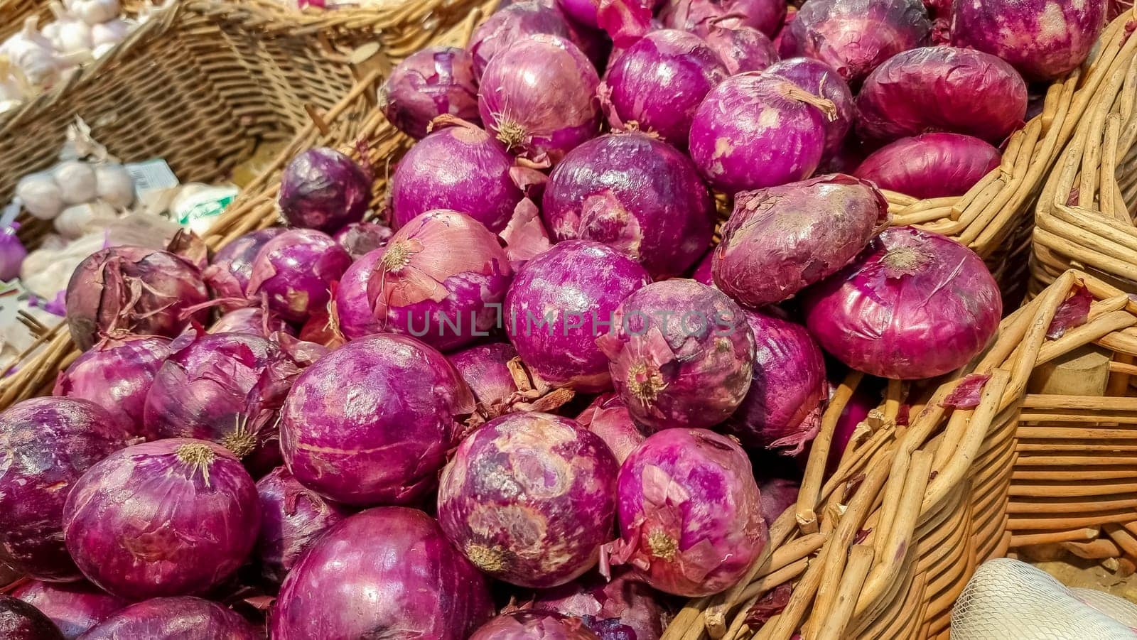 Many heads of red onions in a box