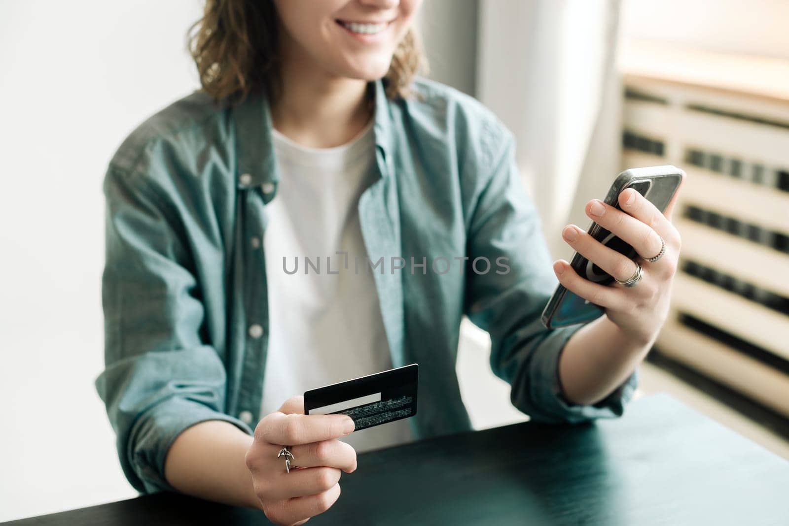 Woman holding credit card and using smartphone at home, businesswoman shopping online, e-commerce, internet banking, spending money, working from home concept.