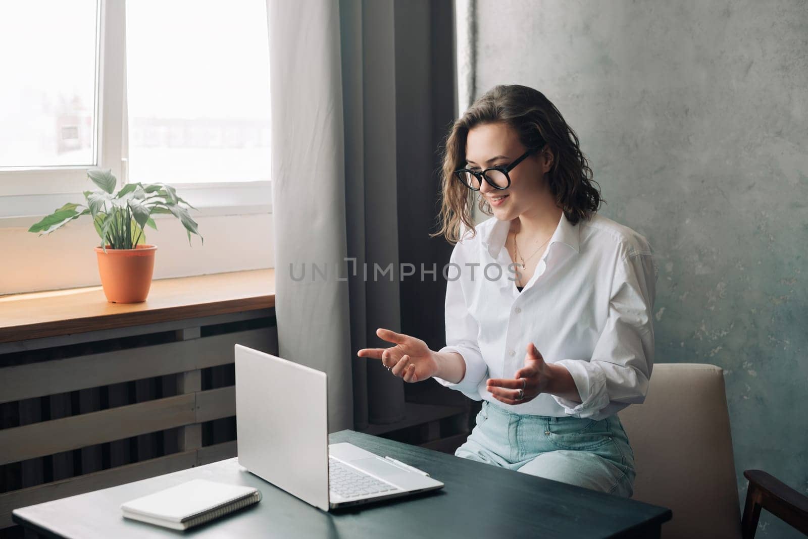 Digital Business Connection: Smiling Young Woman Leading Online Business Briefing, Embracing Remote Work as a Young Businesswoman or Freelancer Engaged in Virtual Collaboration on Laptop