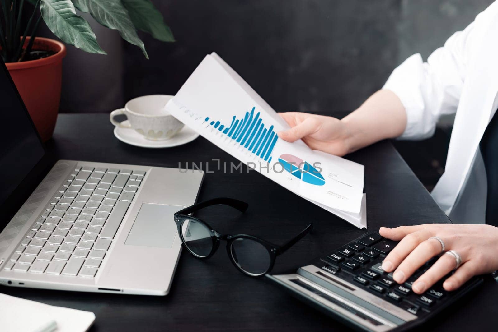Professional Businesswoman Analyzing Financial Budget and Accounting Data in Office, Calculating Finance Report with Calculator, Strategic Financial Analysis and Budgeting in Action.