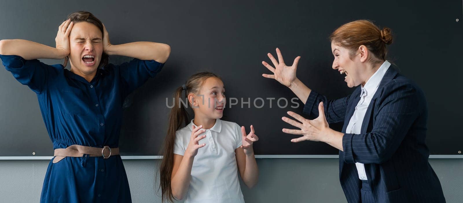 The female teacher screams at the schoolgirl and her mother standing at the blackboard. by mrwed54