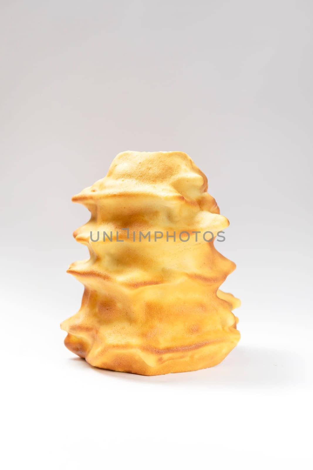 Isokated Sakotis ,sekacz, baumkuchen, traditional spit cake in lithuanian, polish, german, belarusian cuisine made of butter,eggs,flour,sugar, cooked over open fire on white background Vertical plane