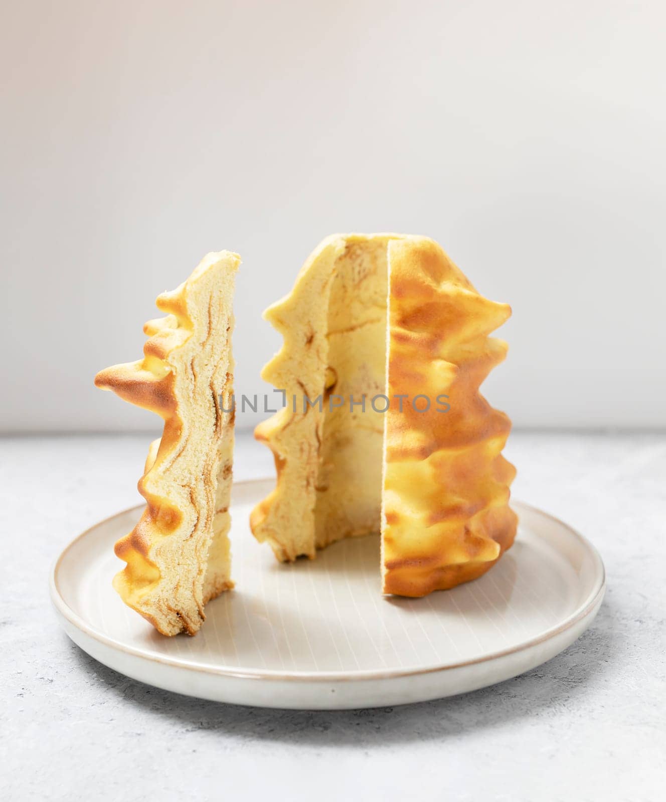 Cut piece of Sakotis ,sekacz, baumkuchen, traditional cake in lithuanian, polish, german, belarusian cuisine made of butter,eggs,flour,sugar, cooked on spit over open fire. Vertical plane.
