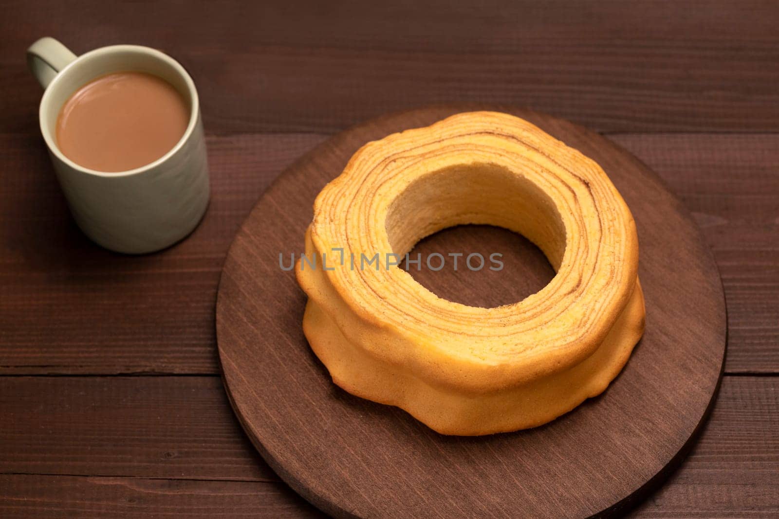 Top view of baumkuchen, sakotis ,sekacz on brown wooden table, delicious homemade traditional spit cake with a cup of coffee. Horizontal plane, flatly.
