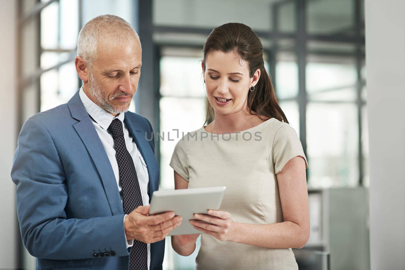 Business people, tablet and communication on a web management project with tech. Staff, corporate team and mature CEO with woman worker planning a internet UI strategy in a office with a conversation.