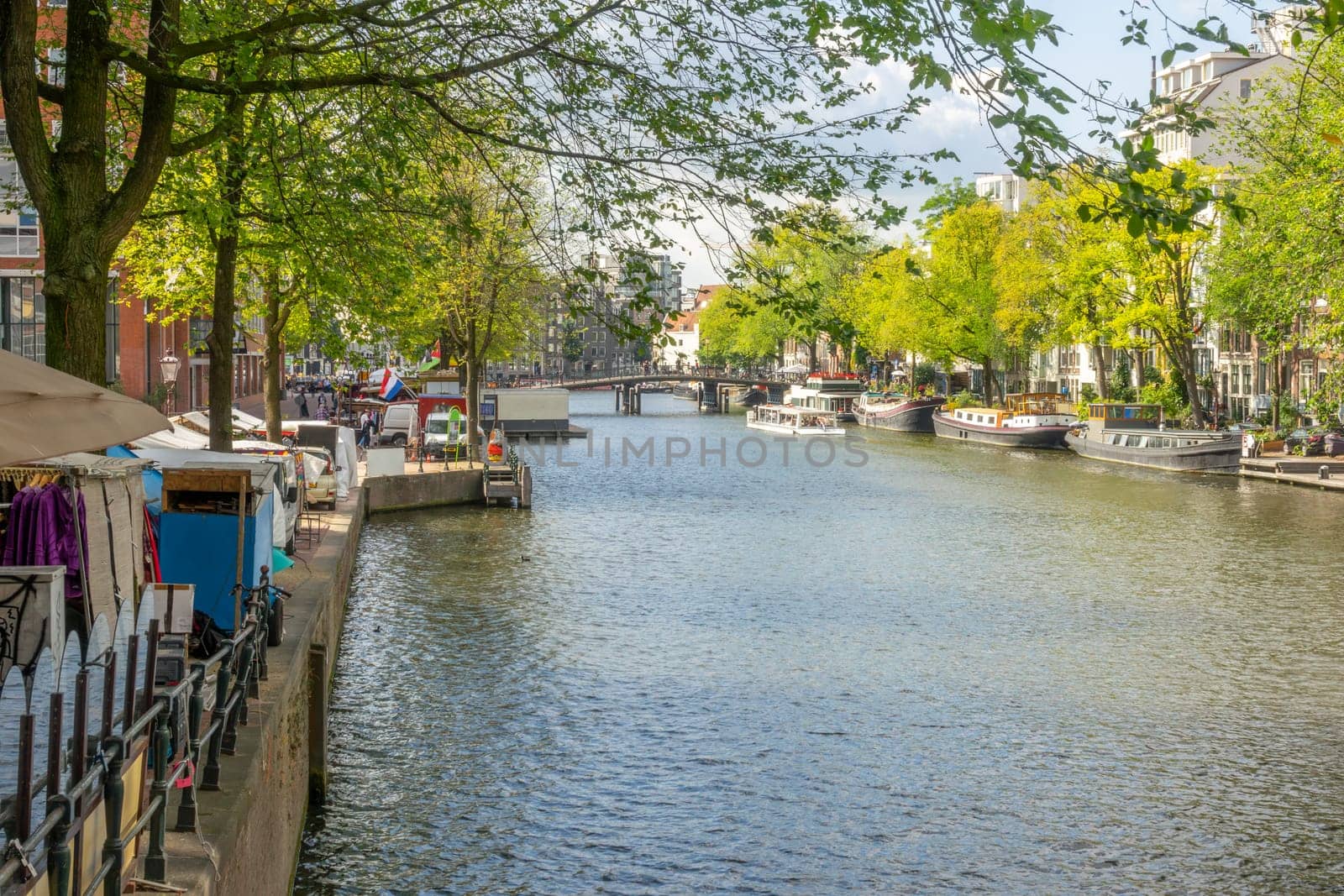 Netherlands. Sunny summer day on a canal in the center of Amsterdam. Large residential barges are moored