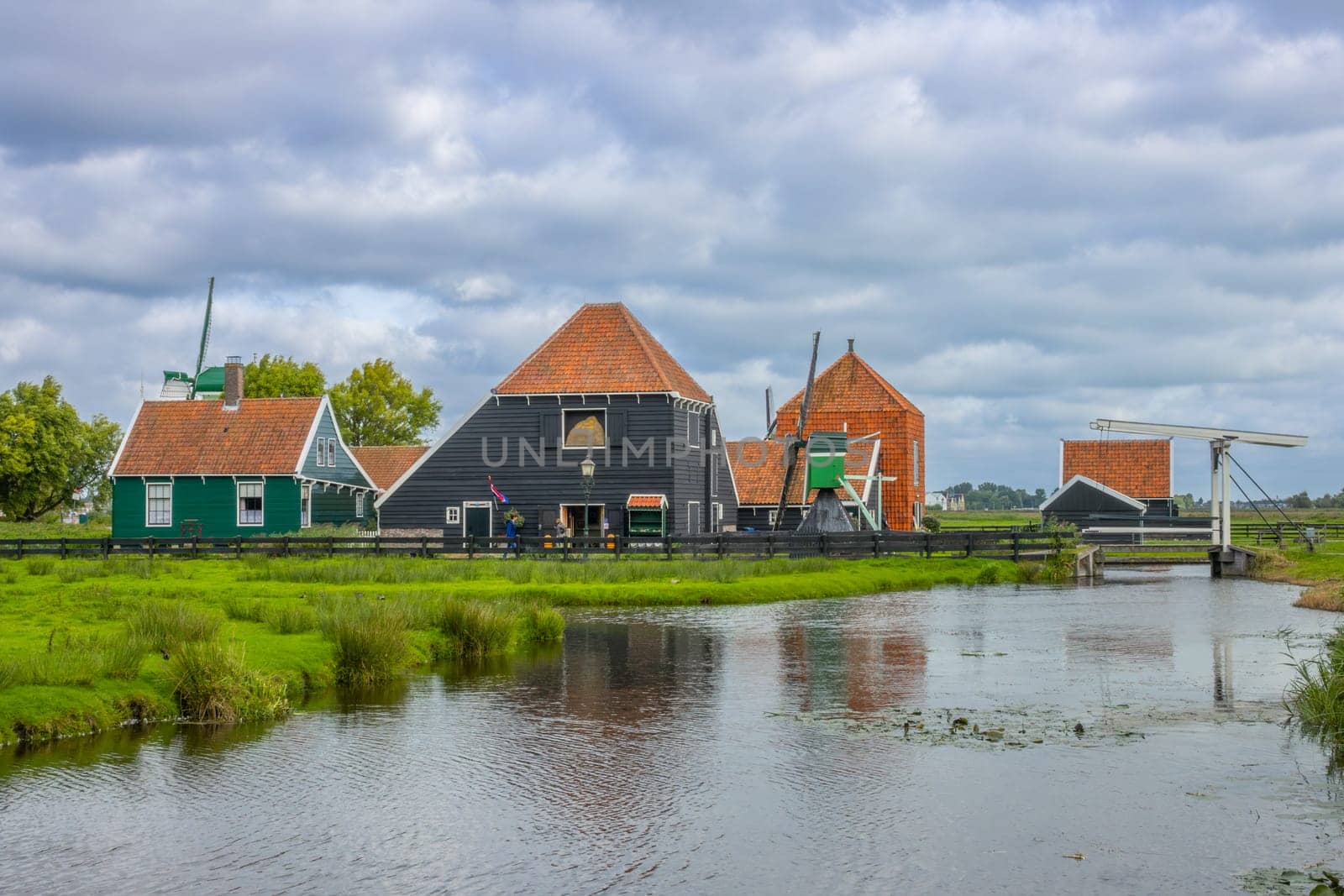 Netherlands. Cloudy summer day in the ancient Zaanse Schans. Several traditional rural houses and a grain barn