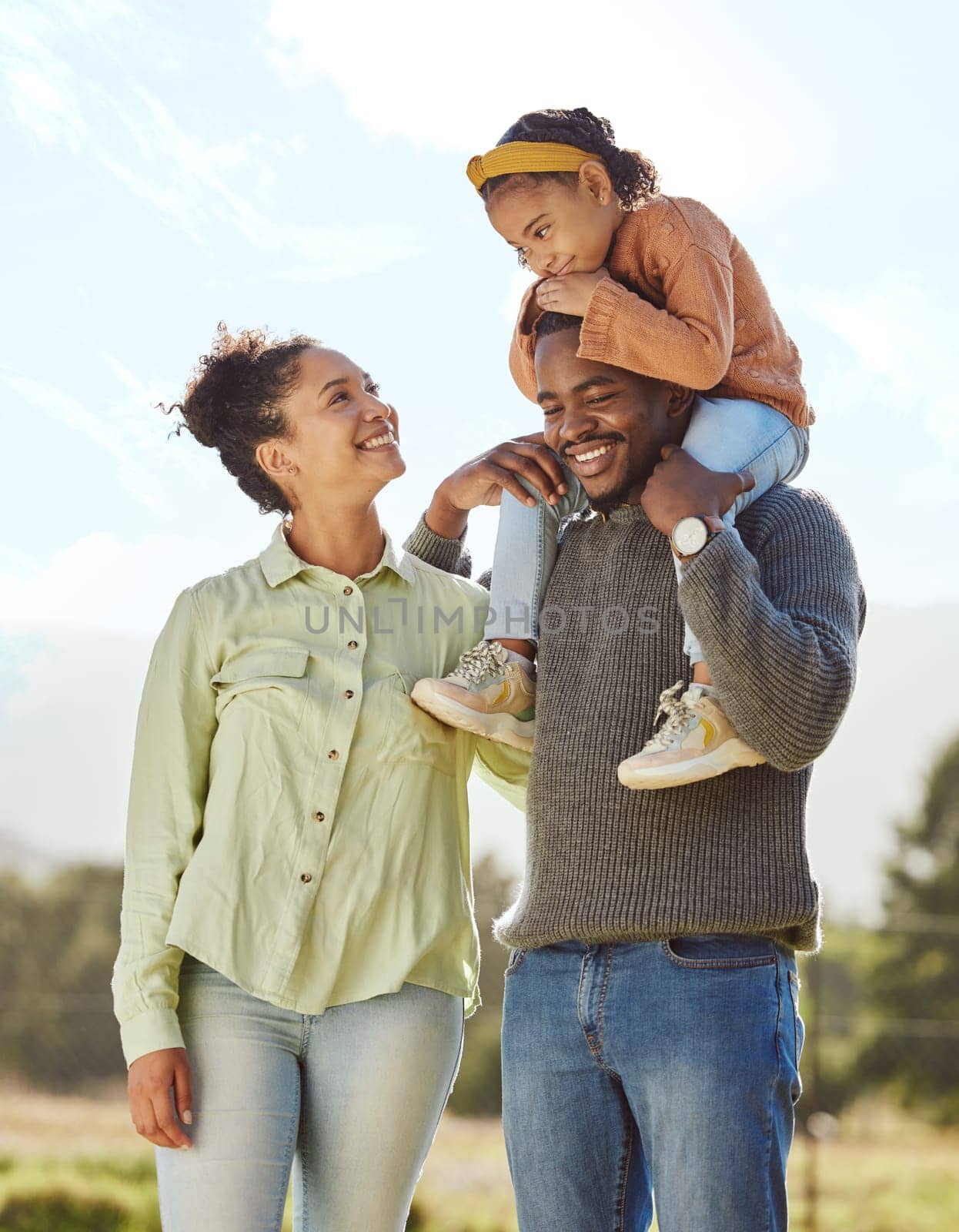 Parents, kids and happy family in park, garden and sunshine field outdoors for bonding, love and quality time together. Mom, dad and girl child of black family having fun, relax and care in nature.