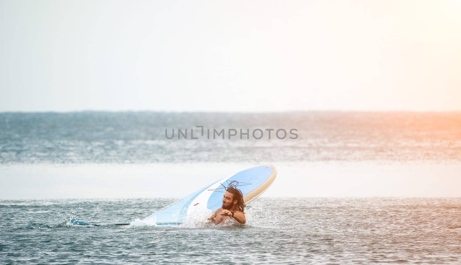 Sea woman and man on sup. Silhouette of happy young woman and man, surfing on SUP board, confident paddling through water surface. Idyllic sunset. Active lifestyle at sea or river