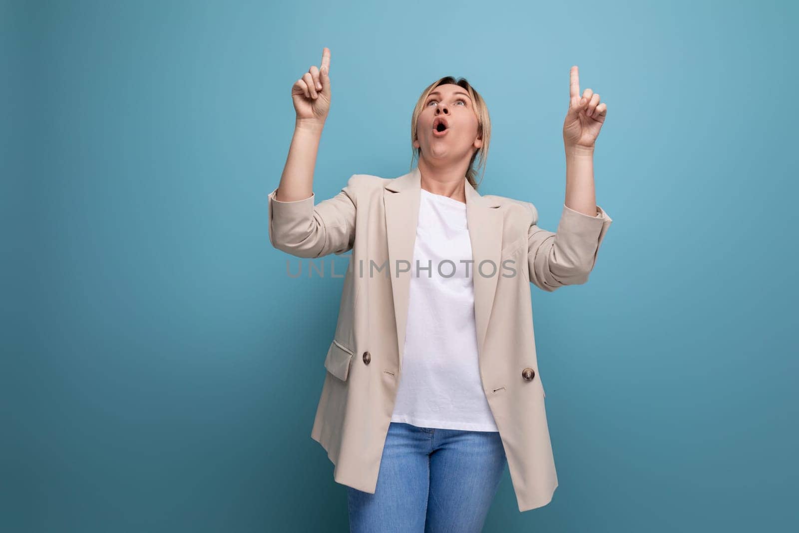 close-up of positive cheerful blonde business woman demonstrating having an idea with hands on blue background with copy space.