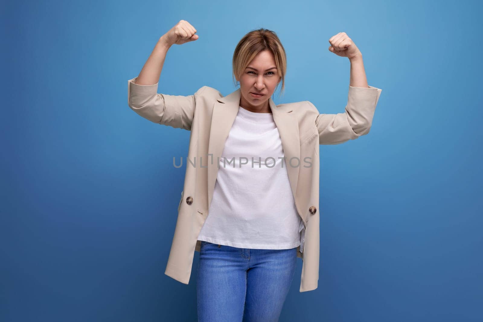 portrait of well-groomed european positive blond young woman in casual style on studio background.