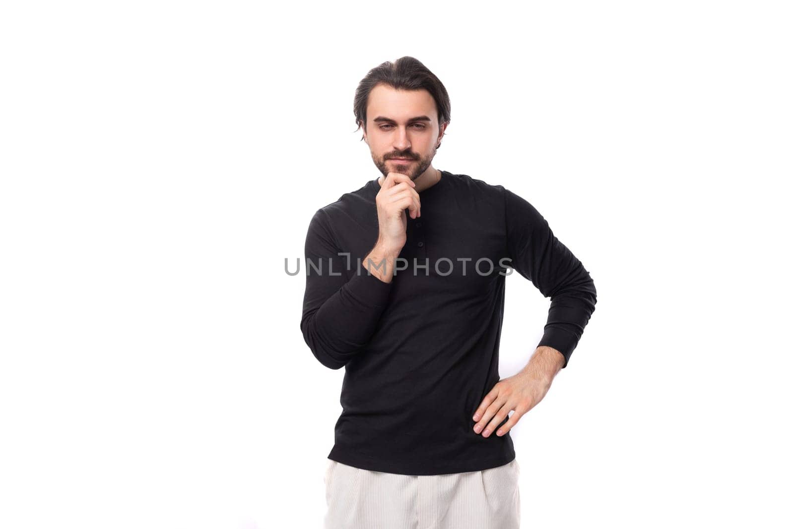 close-up of a young well-groomed brunette man with a haircut and a beard dressed in a black jacket isolated on a white background with copy space by TRMK