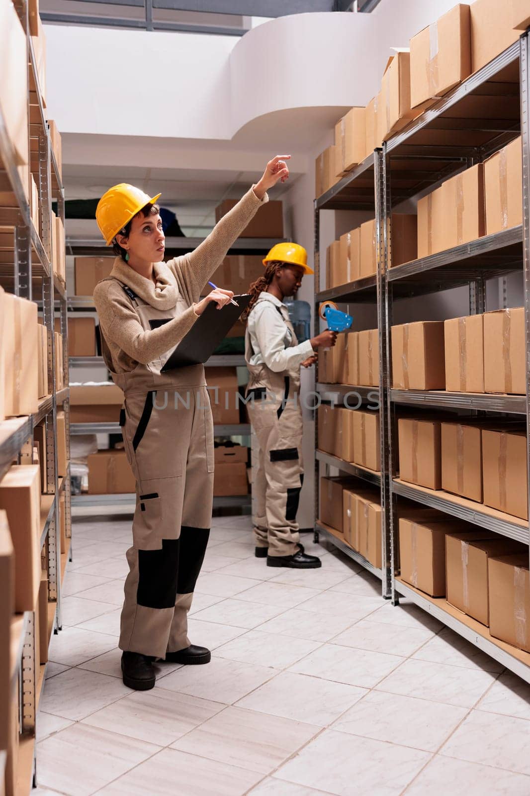 Storage employees coordinating shipping and preparing boxes before transportation by DCStudio