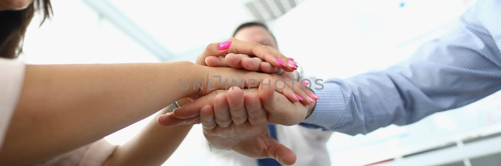 Closeup of business partners making bunch of hands in meeting. Profitable business cooperation and team success concept