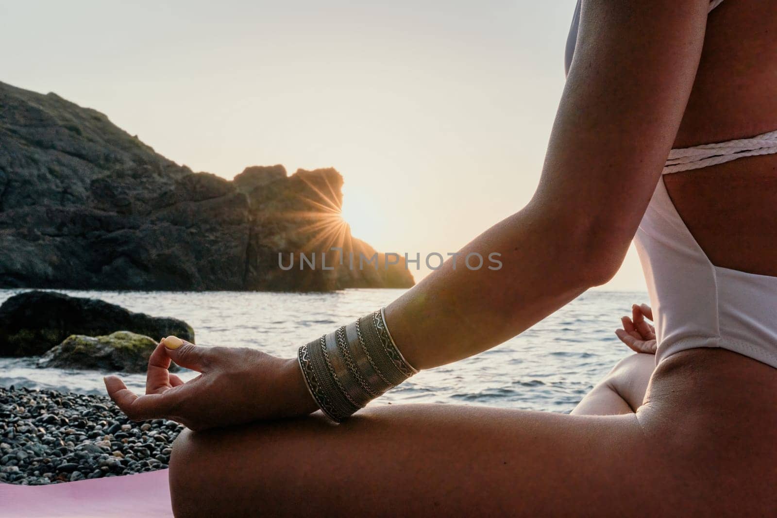 Woman sea yoga. Back view of free calm happy satisfied woman with long hair standing on top rock with yoga position against of sky by the sea. Healthy lifestyle outdoors in nature, fitness concept.