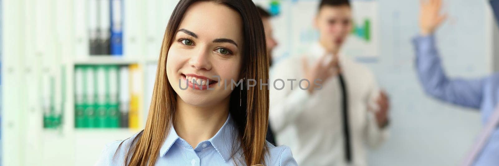 Business woman with staff and group of people in background in office. Educational seminar lecture concept