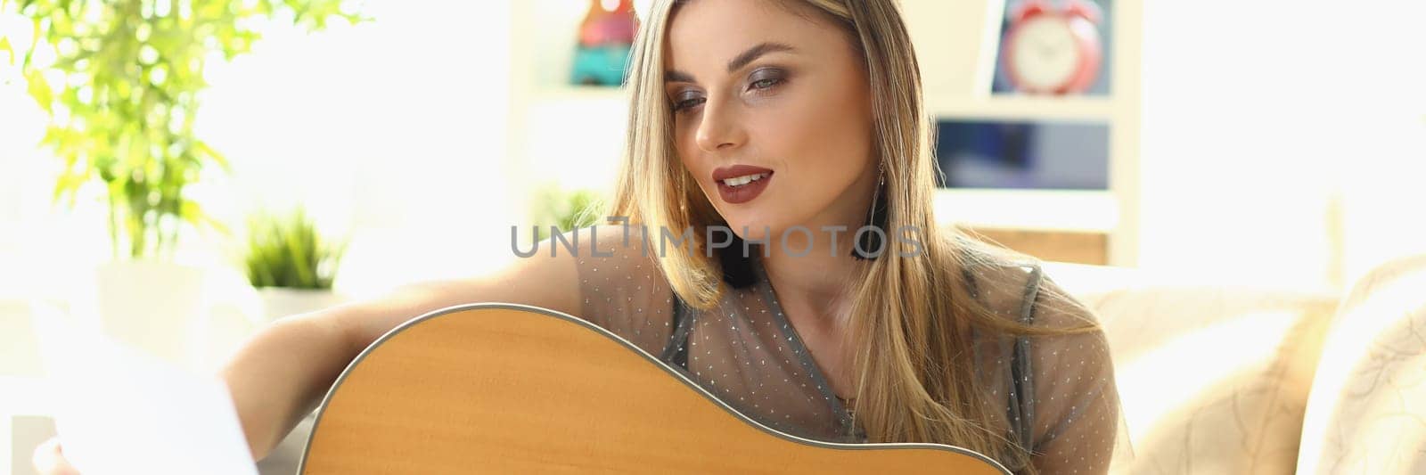Woman is learning new song to play acoustic guitar by kuprevich
