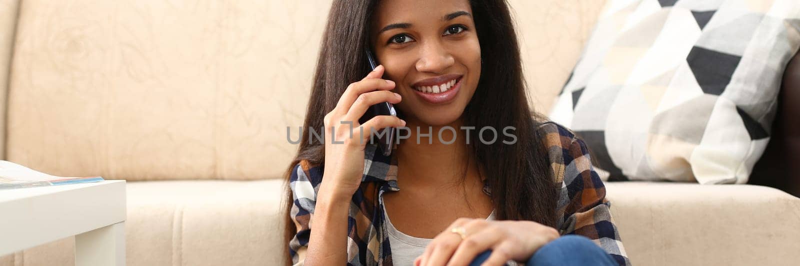 Happy positive beautiful black woman talking on mobile phone from home. Young beautiful afro woman enjoying talking on phone