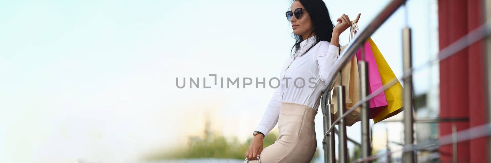 Beautiful girl in sunglasses holds shopping bags. Shopping discount sale concept