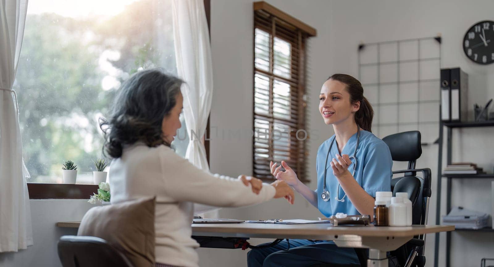 Senior care, healthcare insurance and caregiver woman sitting with elderly woman patient laughing and talking while enjoying retirement home. Old lady and female nurse hospice with health check form.