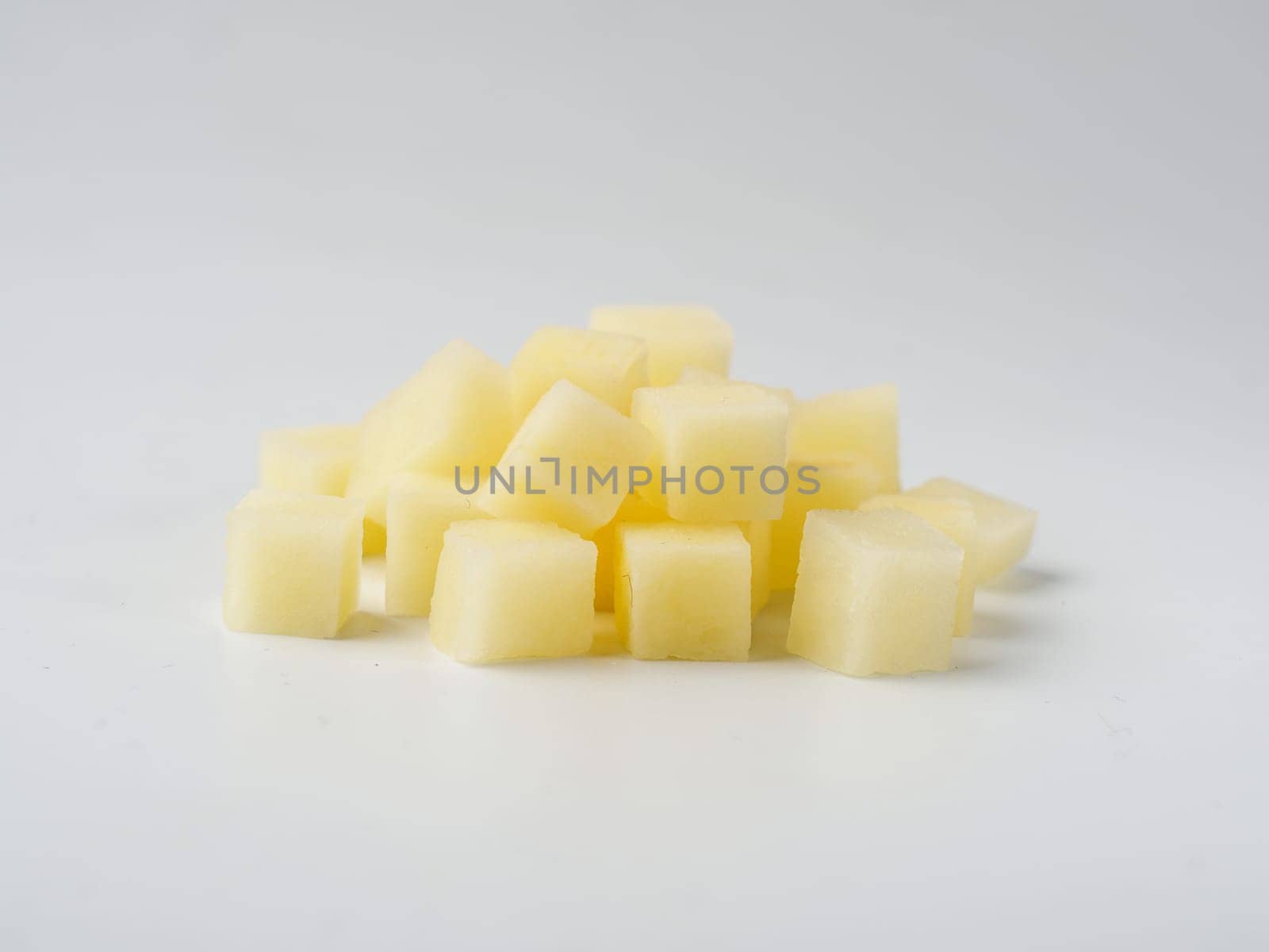 Heap of diced raw potatoes isolated on white background. Pile uncooked potatoes cube.