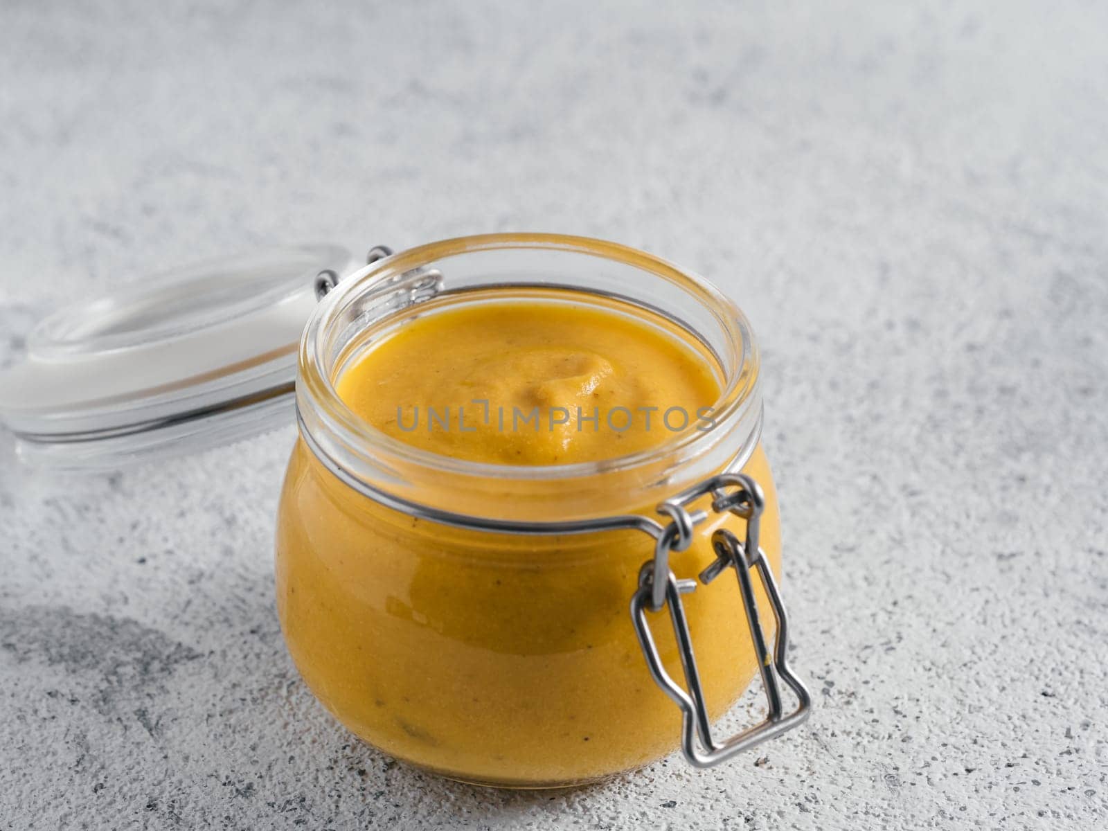Creamy Cheddar sauce with chia seeds on gray background.Ideas and recipe for healthy diet or vegan food.Homemade Chia Cheeze Sauce for snacks,tacos,nachos,dipping,mac-n-cheese,base for pizza.Copyspace
