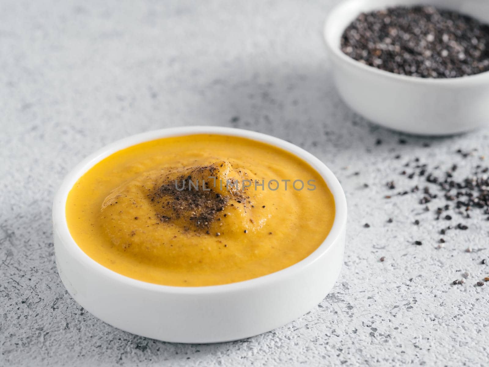 Creamy Cheddar sauce with chia seeds on gray background.Ideas and recipe for healthy diet or vegan food.Homemade Chia Cheeze Sauce for snacks,tacos,nachos,dipping,mac-n-cheese,base for pizza.Copyspace