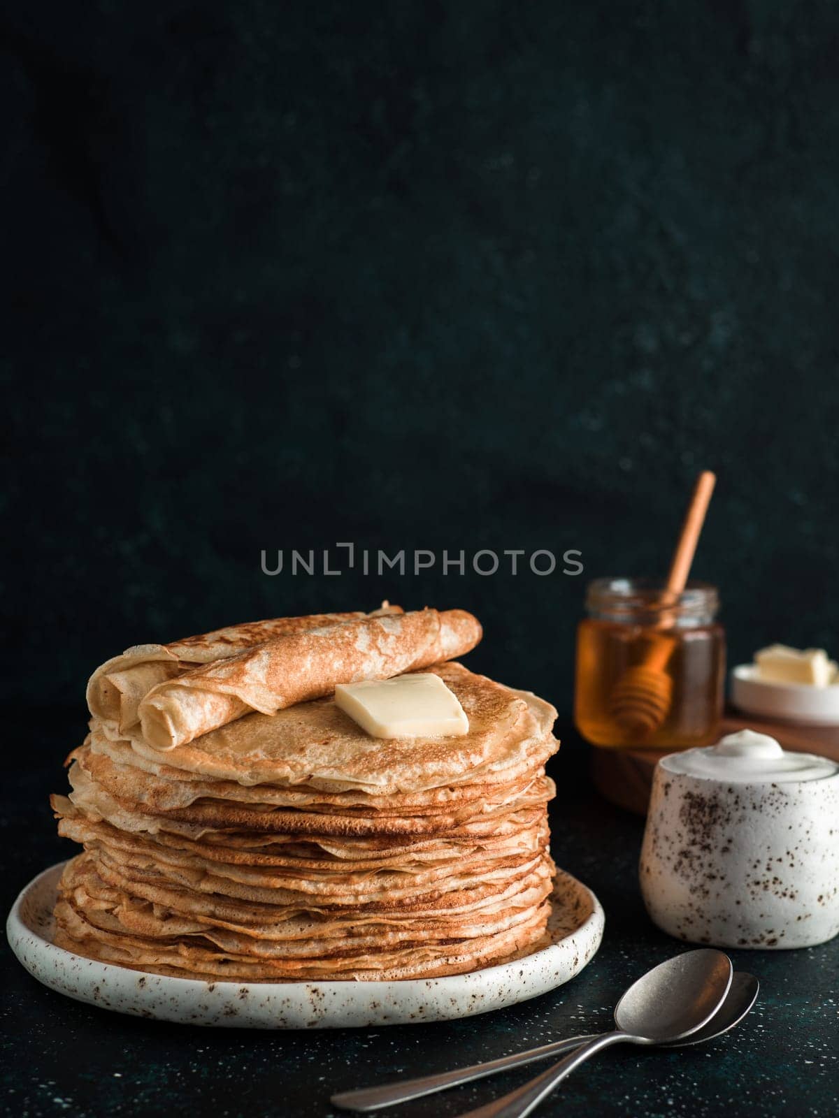 Stack of traditional russian pancakes blini on black background with copy space. Homemade russian thin pancakes blini. Russian food, russian kitchen
