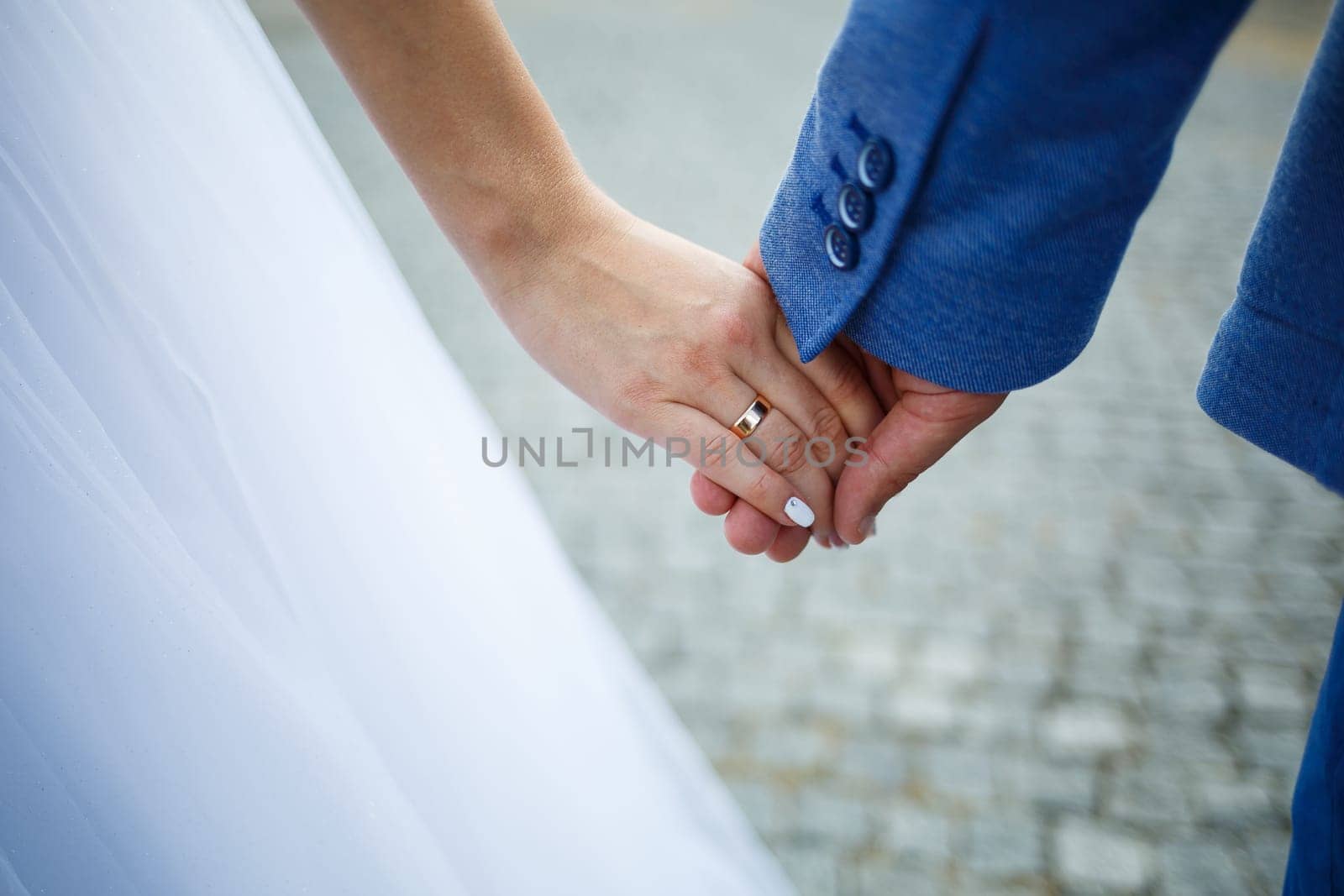 gold wedding rings in the hands of the newlyweds