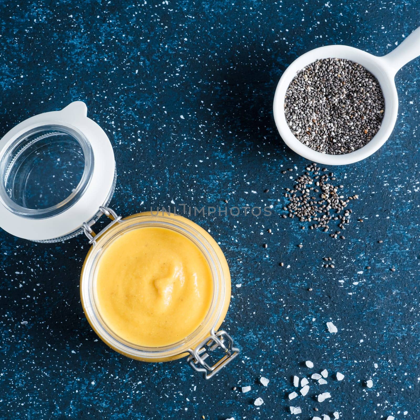 Creamy Cheddar sauce with chia seeds on dark background.Ideas and recipe for healthy diet or vegan food.Homemade Chia Cheeze Sauce for snacks,tacos,nachos,dipping,mac-n-cheese,base for pizza.Copyspace