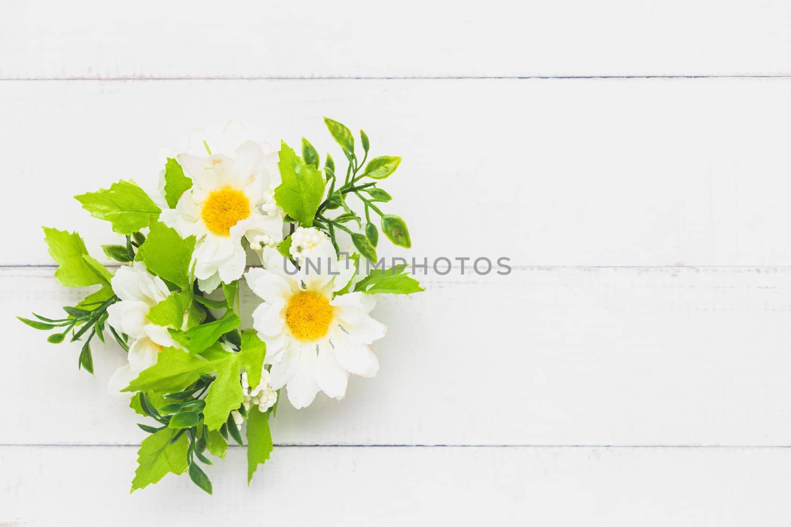Top view of a fake bunch of flowers on white table background for nature decoration and springtime concept
