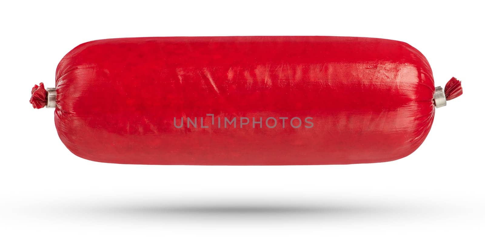 Packed salami sausage close-up on a white isolated background. The sausage hangs or falls, casting a shadow. Salami is packed in a red protective film