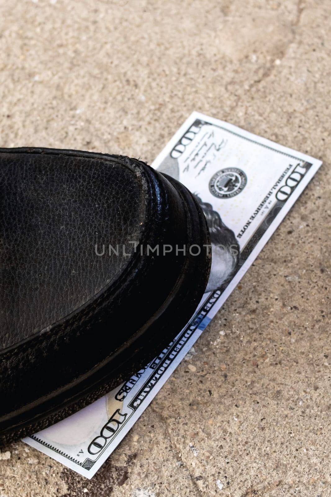 One hundred dollar bill under the shoe close up