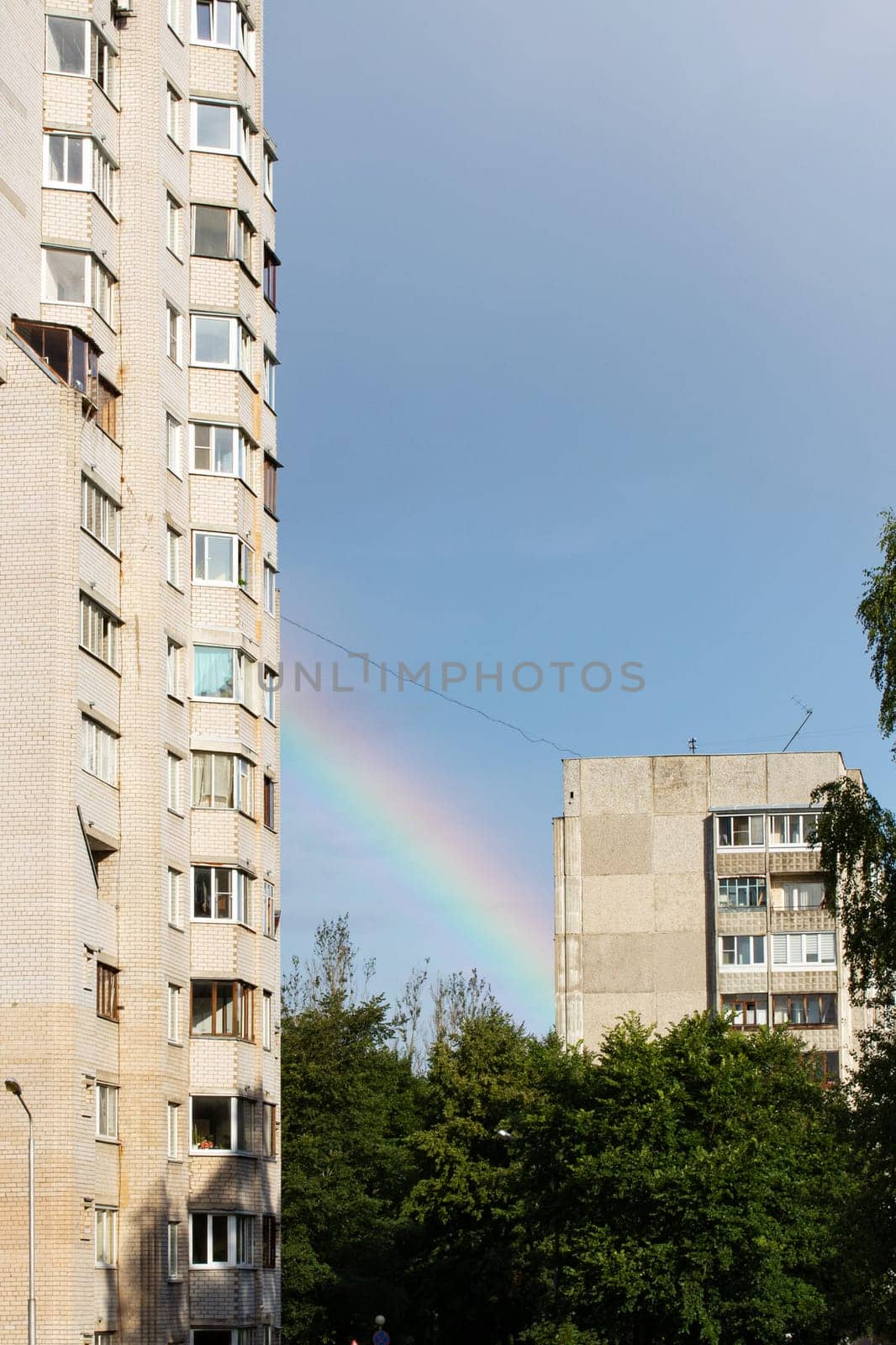 Rainbow in the sky in the city in summer