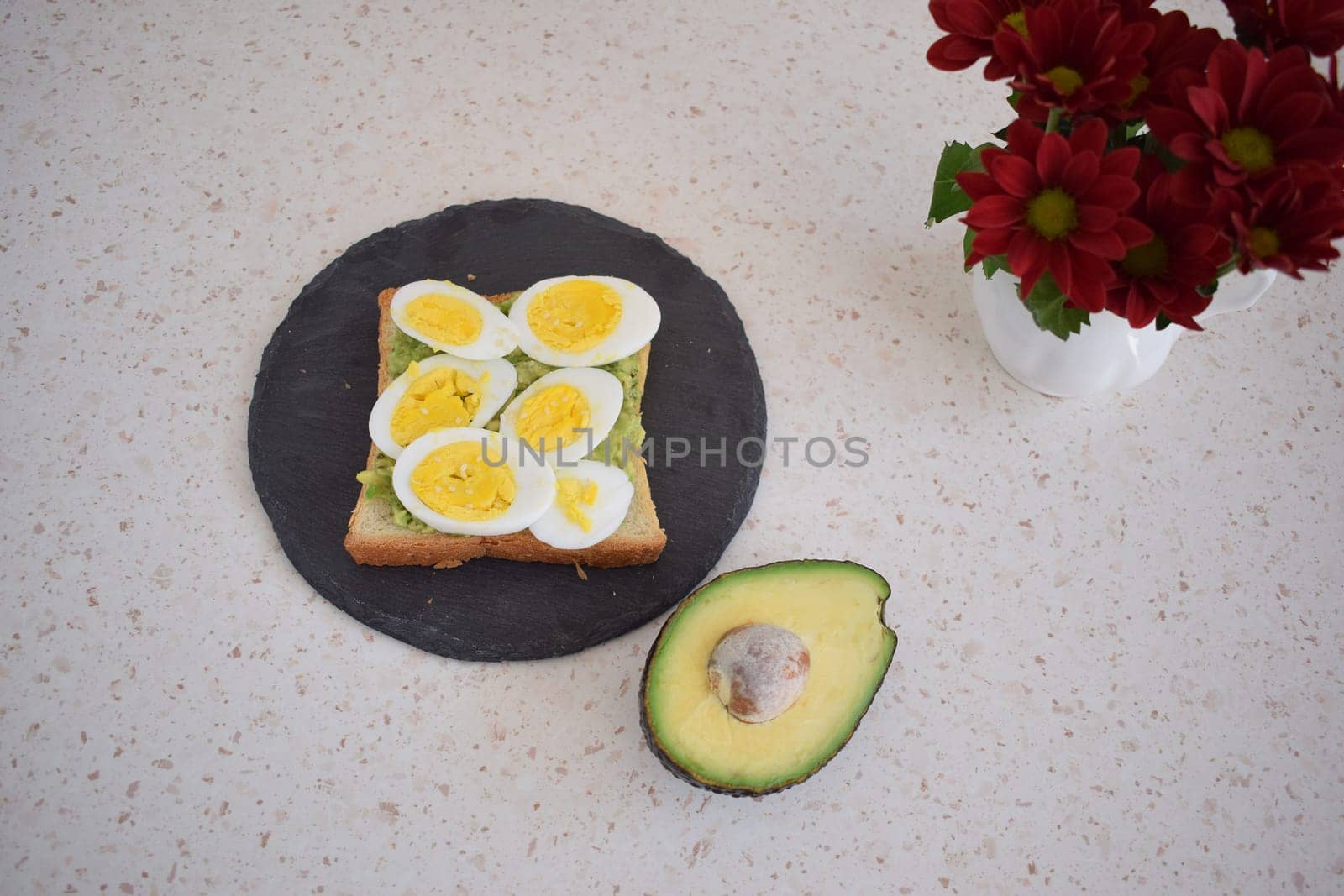 Healthy breakfast toast with egg, avocado and herbs.