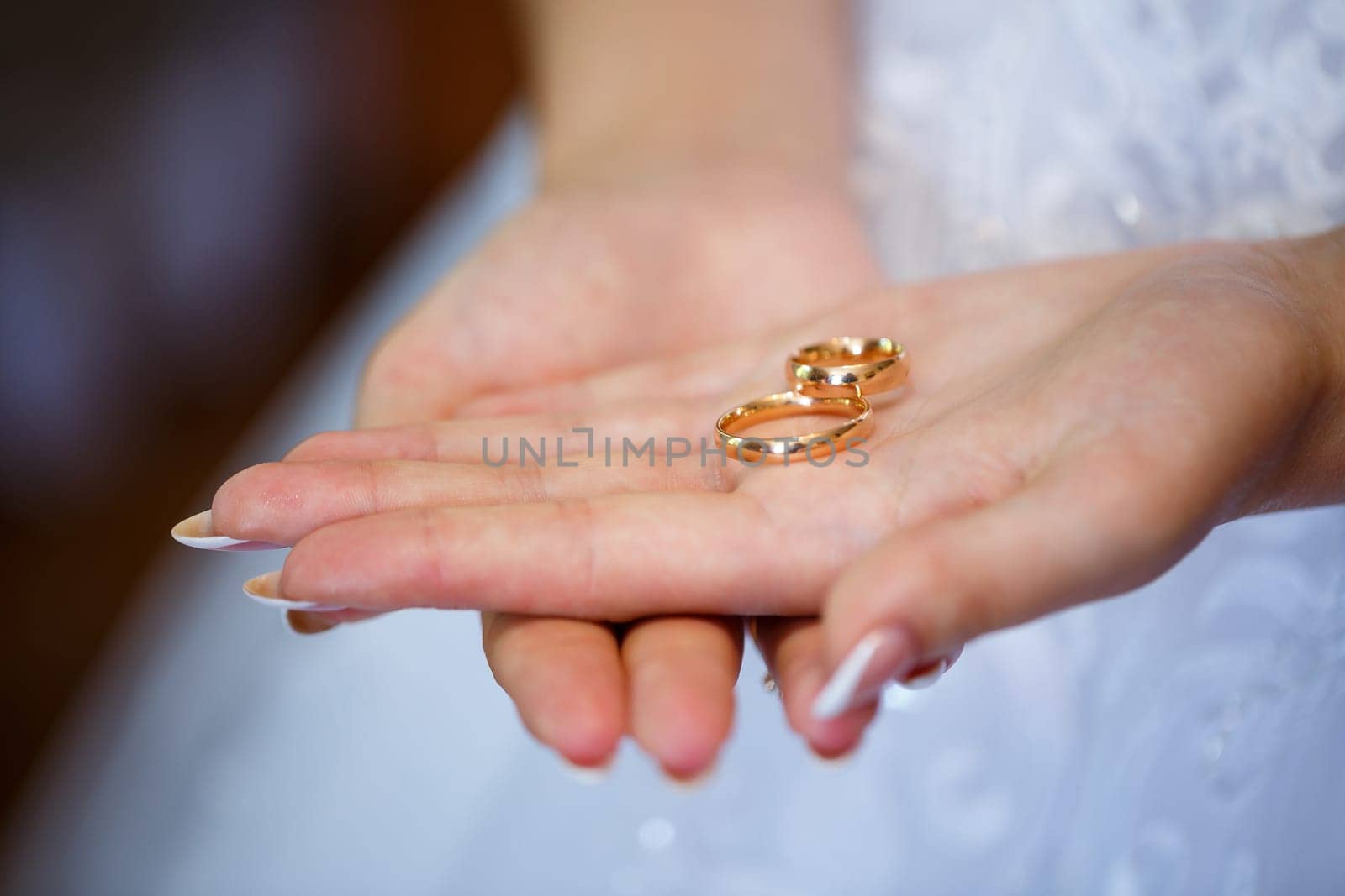 gold wedding rings in hands of newlyweds on wedding day by Dmitrytph