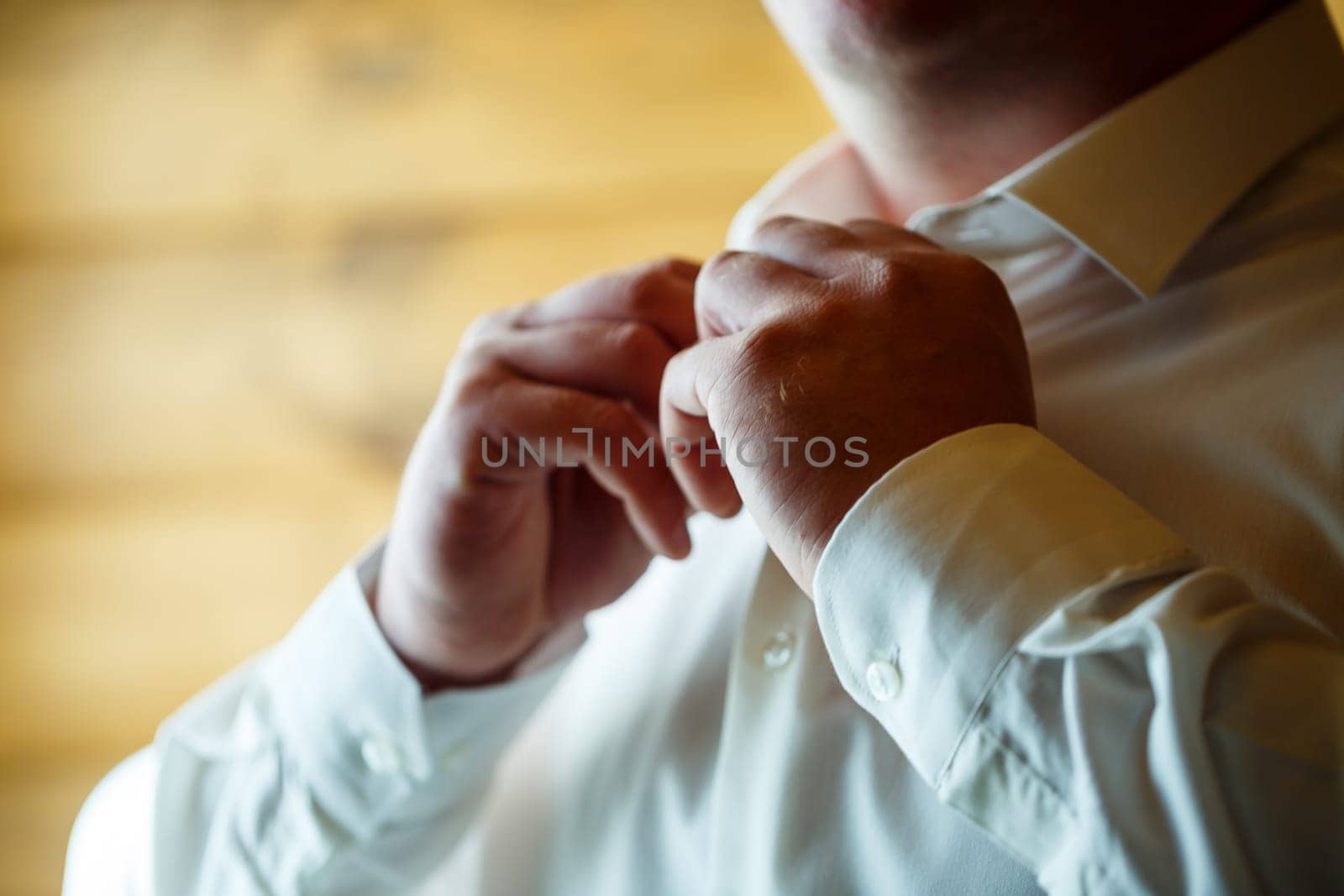 Man puts on a wedding suit and accessories on the wedding day.