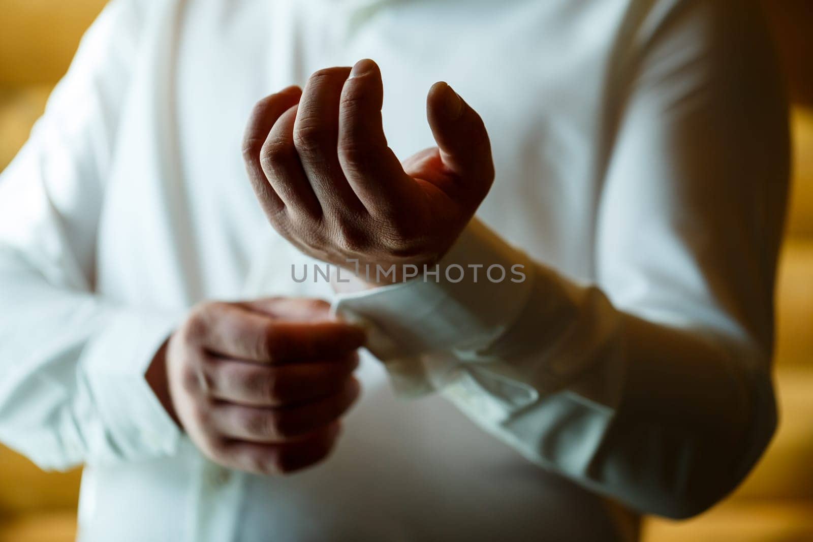 Man puts on a wedding suit and accessories on the wedding day.