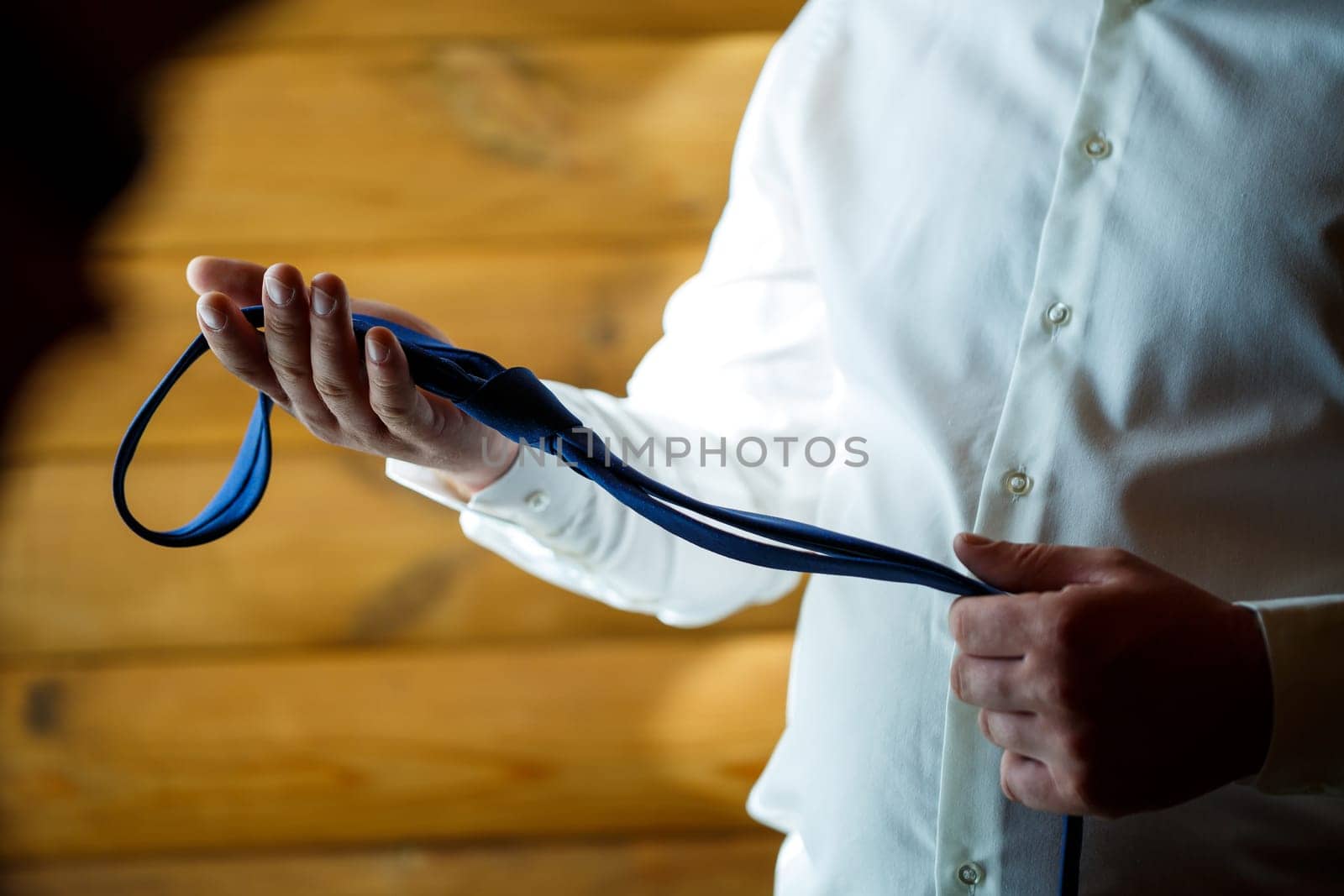 Man puts on a wedding suit and accessories on the wedding day.