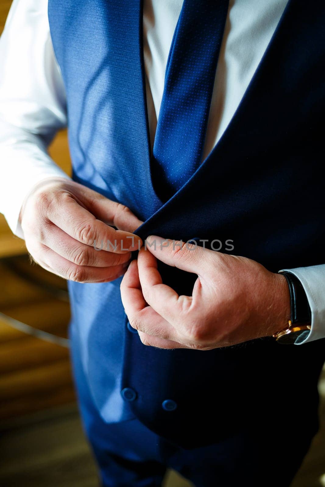 Man puts on a wedding suit and accessories on the wedding day. by Dmitrytph