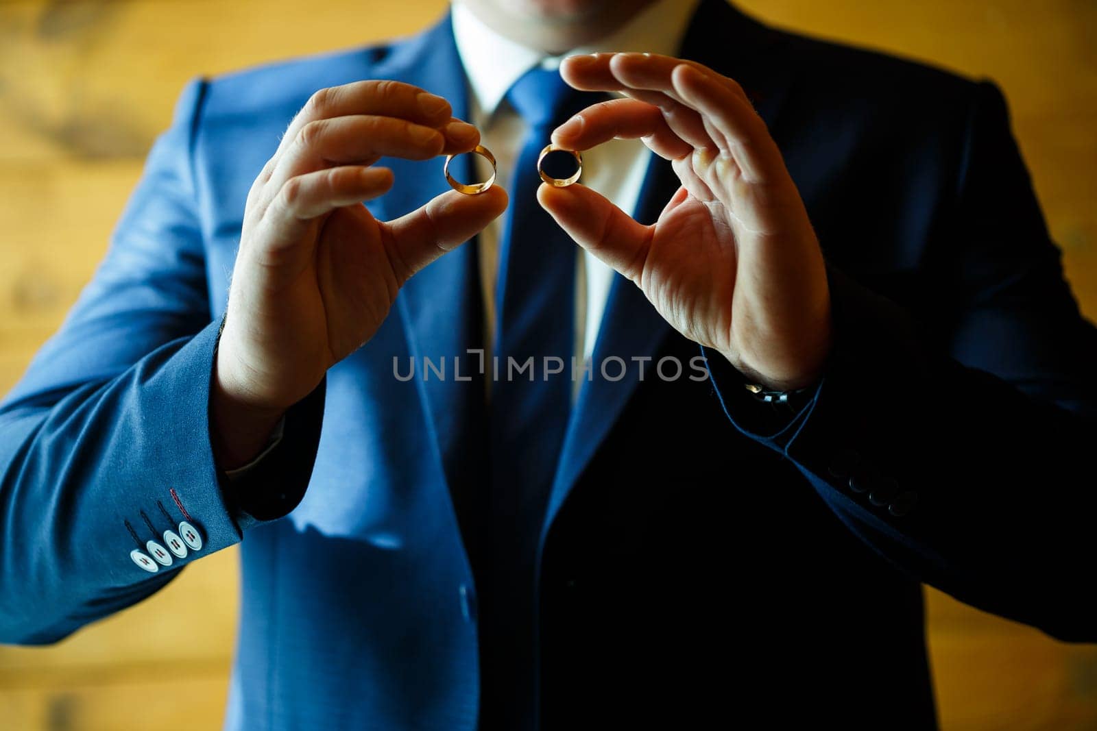 gold wedding rings in the hands of the newlyweds