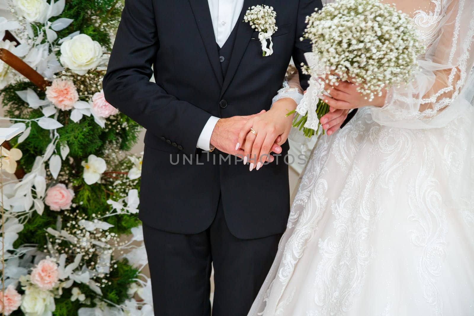 Wedding bouquet with fresh natural flowers in the hands of the bride