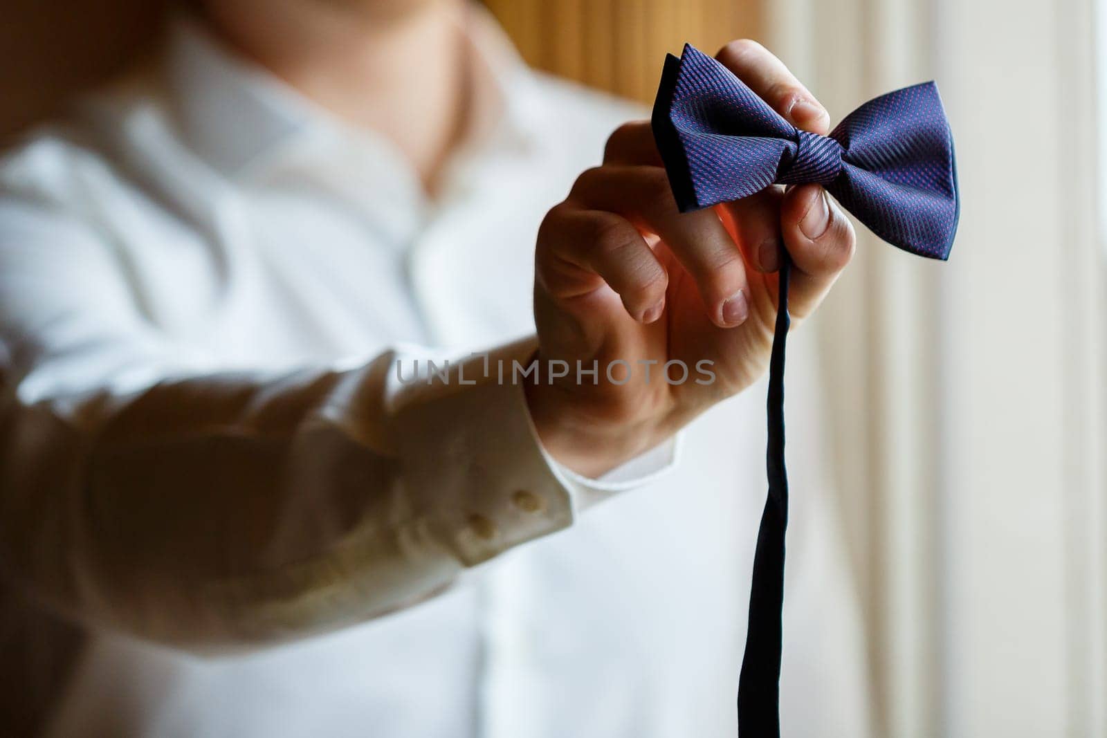 Man puts on a wedding suit and accessories on the wedding day.