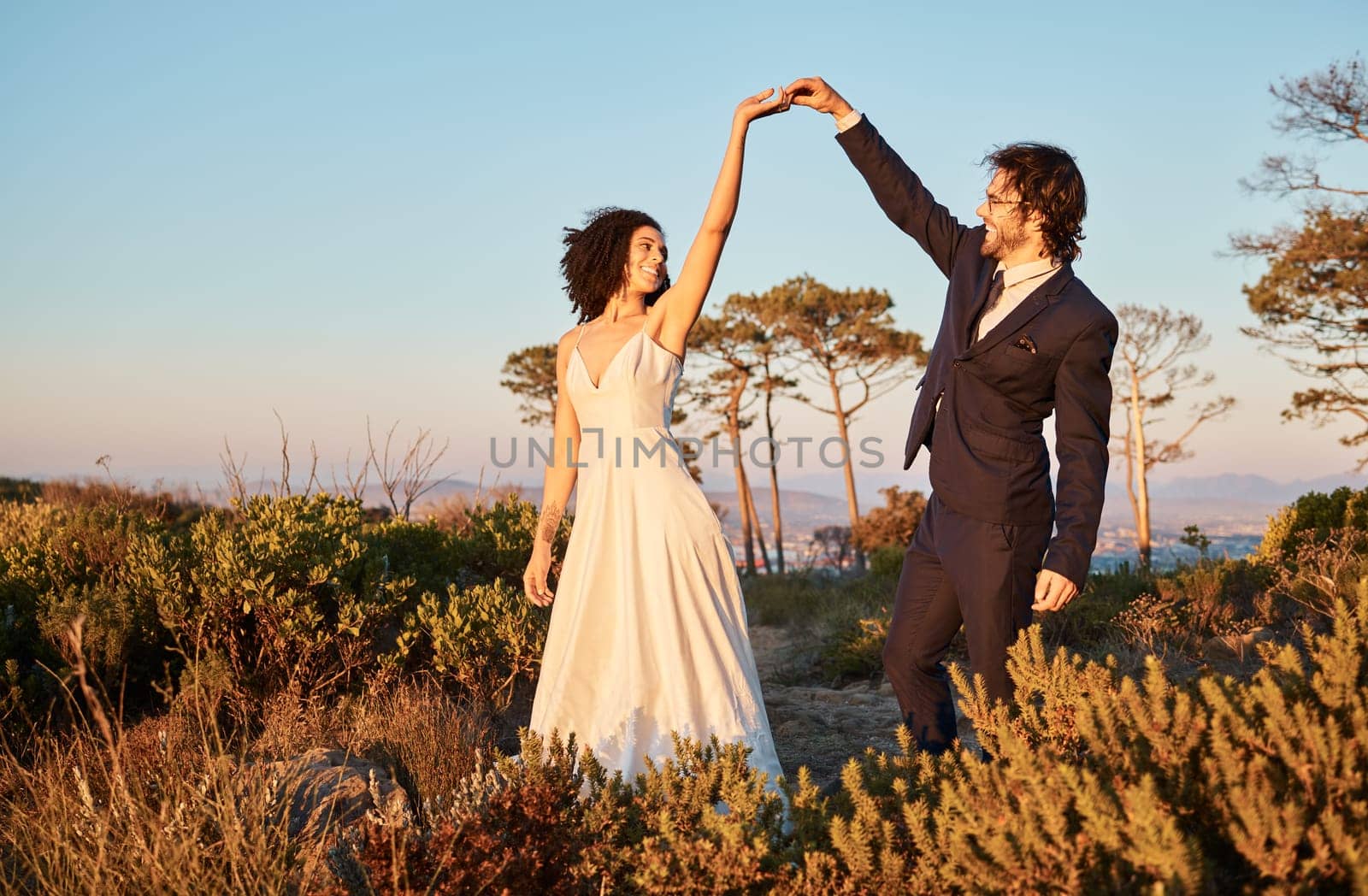 Love, wedding and holding hands for dance with couple in nature park for celebration, romance and happiness. Sunset, support and summer with bride and groom for marriage, ceremony and bonding.