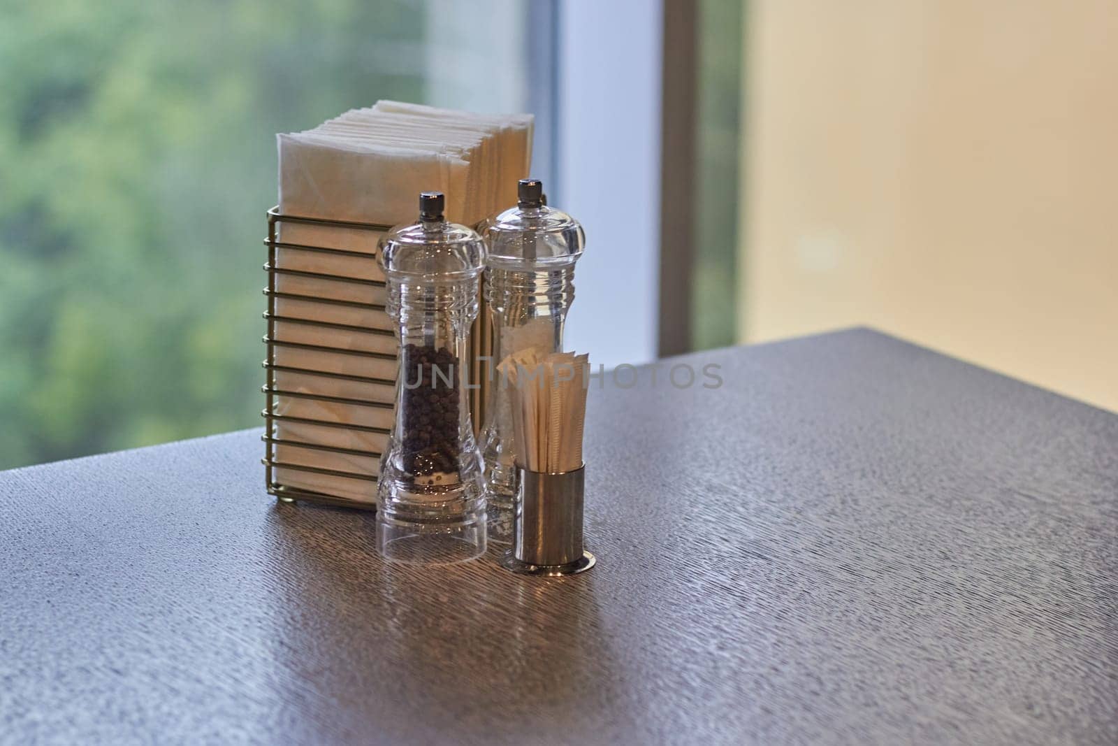 Photo of spice toothpick and napkin in holder on table. Table setting in cafes and restaurants.