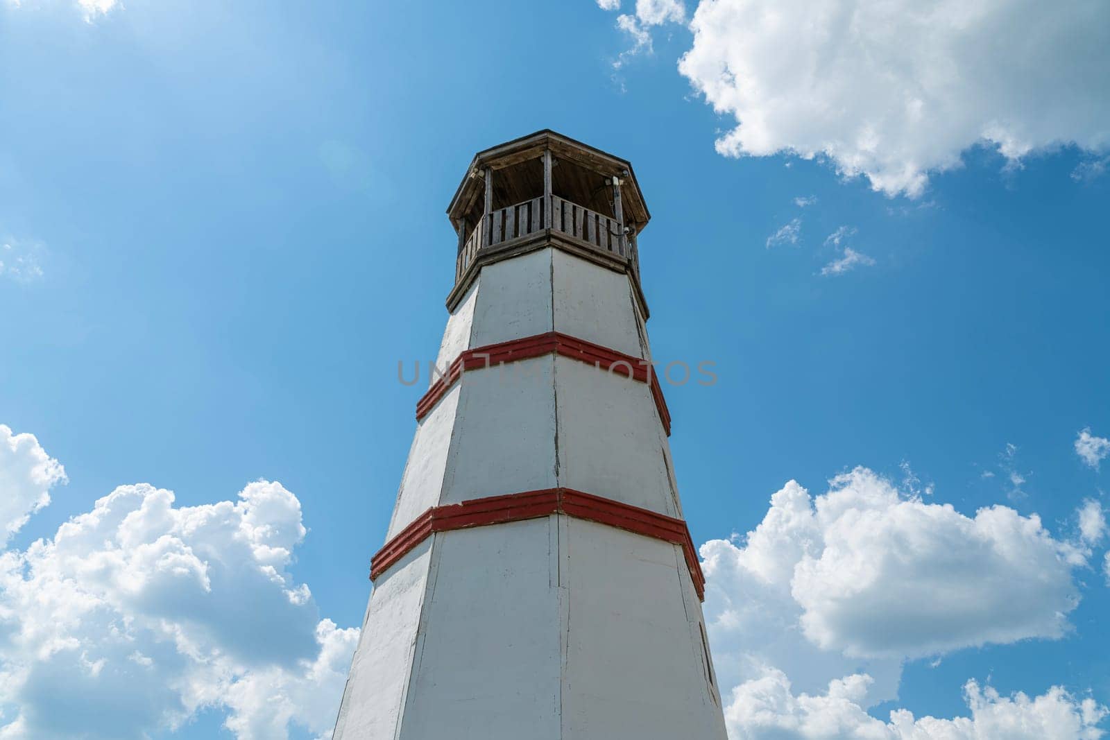 the old lighthouse against the blue sky by roman112007