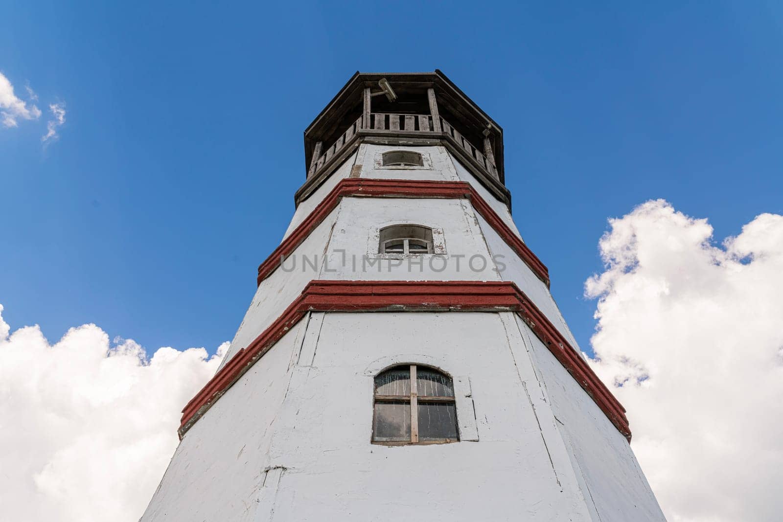 the old lighthouse against the blue sky by roman112007