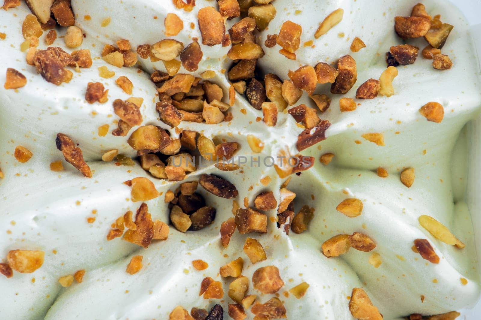 Texture of ice cream with pistachios. Ice cream closeup. The concept of treats for children and adults. For advertising stand. by SERSOL