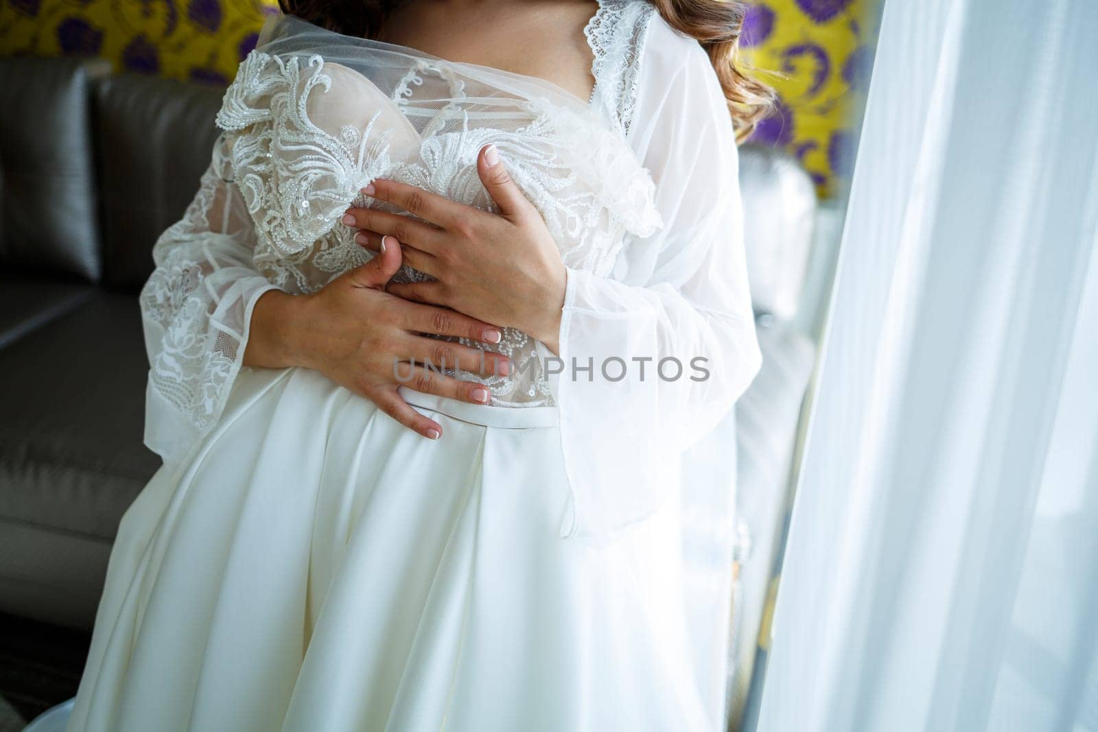 the bride holds in her hands a beautiful wedding dress