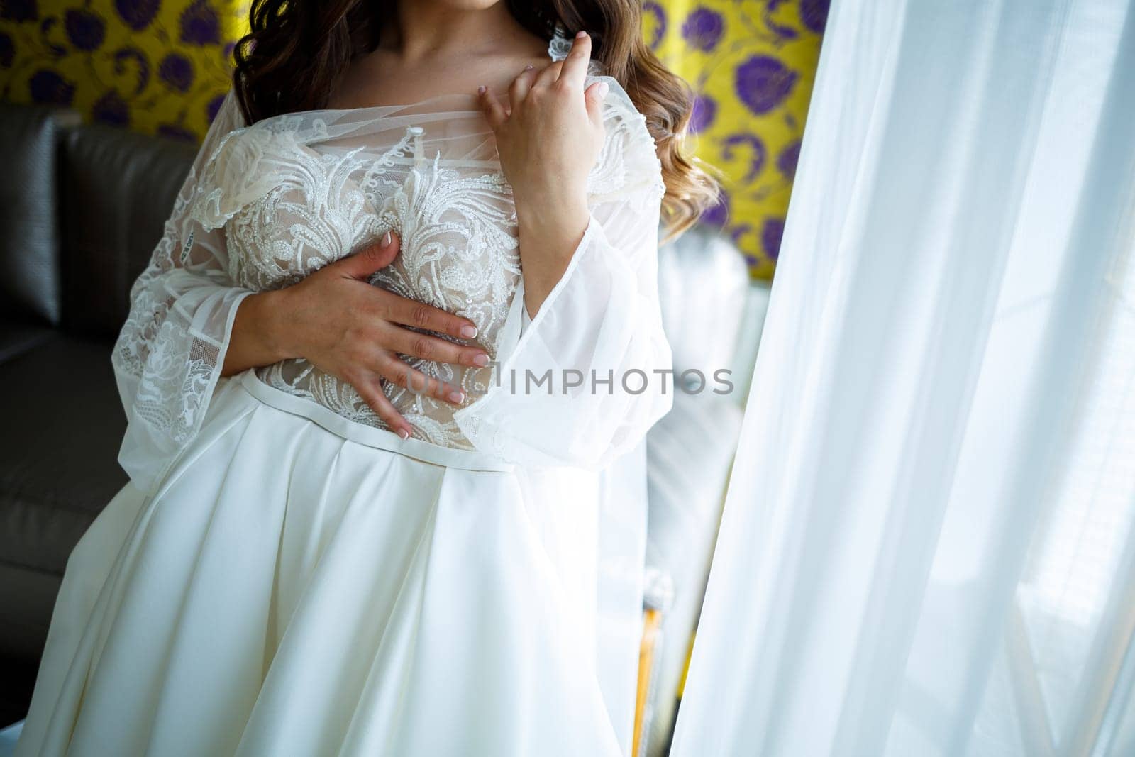 the bride holds in her hands a beautiful wedding dress